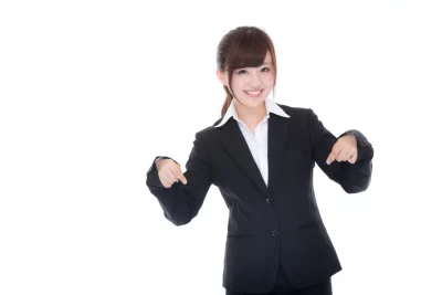 「詳細はこちらから！」と指をさす女性のフリー写真素材